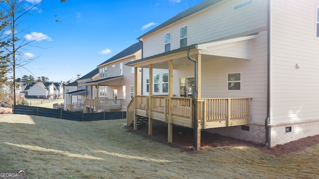 rear view of house with a deck and a lawn