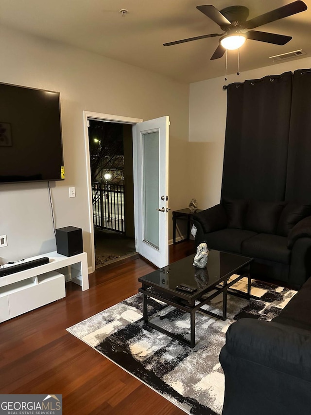 living room with dark wood-type flooring and ceiling fan