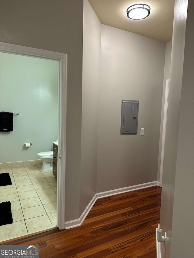 bathroom featuring vanity, toilet, electric panel, and hardwood / wood-style floors