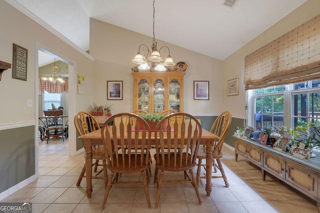 dining space with an inviting chandelier, a wealth of natural light, lofted ceiling, and light tile patterned flooring