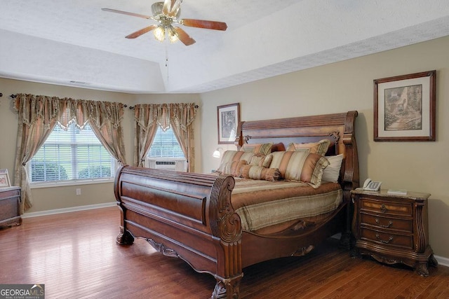 bedroom featuring hardwood / wood-style flooring, a raised ceiling, lofted ceiling, and ceiling fan