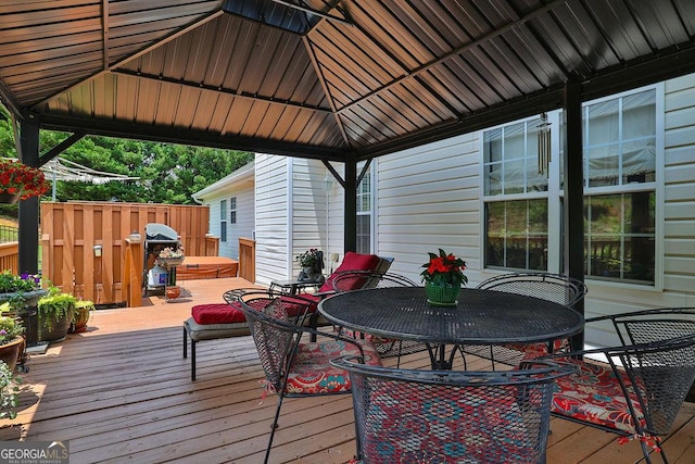 wooden terrace with a hot tub and a gazebo