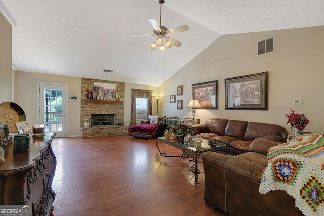 living room with vaulted ceiling, dark wood-type flooring, ceiling fan, and a fireplace