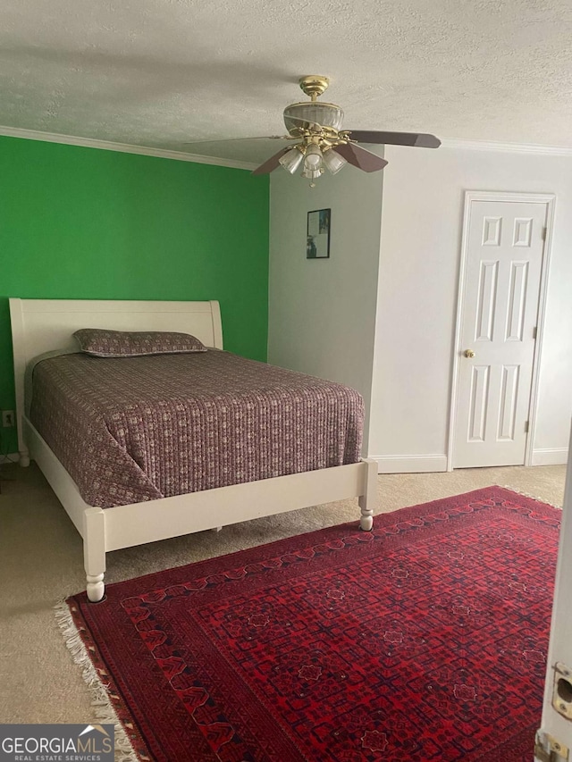 bedroom with ceiling fan, carpet, crown molding, and a textured ceiling