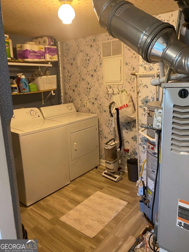 clothes washing area featuring washing machine and dryer and light wood-type flooring