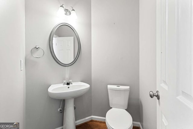 bathroom featuring wood-type flooring, sink, and toilet