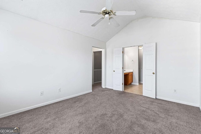 unfurnished bedroom with lofted ceiling, light carpet, connected bathroom, and ceiling fan