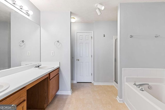 bathroom featuring vanity, plus walk in shower, and a textured ceiling