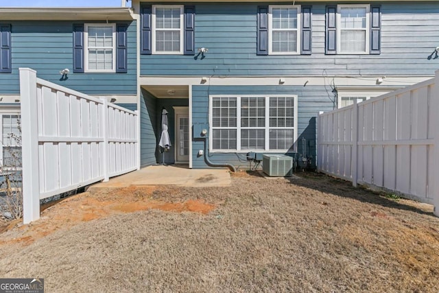 back of property featuring cooling unit and a yard