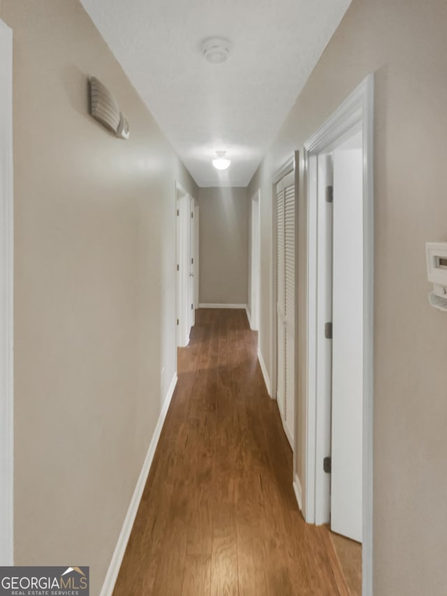 corridor with wood-type flooring