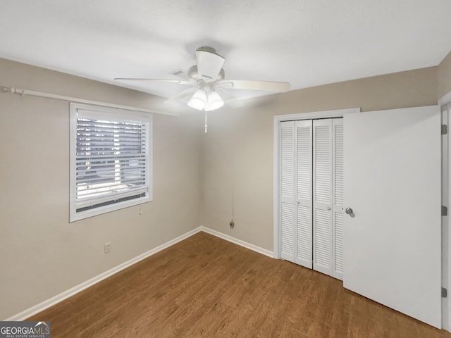 unfurnished bedroom featuring hardwood / wood-style flooring, ceiling fan, and a closet