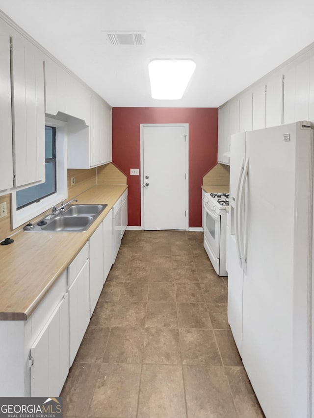 kitchen with tasteful backsplash, white appliances, sink, and white cabinets