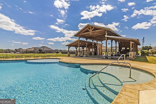 community pool featuring a gazebo, a patio area, a yard, and fence