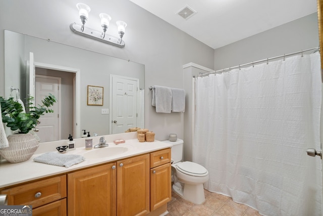 bathroom featuring vanity, tile patterned flooring, and toilet