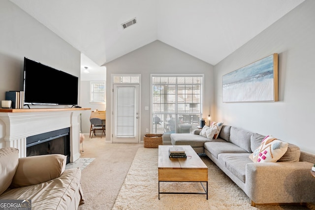 carpeted living room with vaulted ceiling