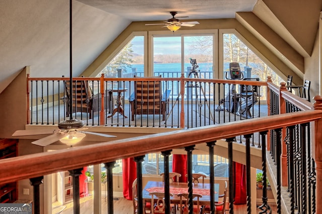 interior space featuring a water view, a healthy amount of sunlight, lofted ceiling, and ceiling fan