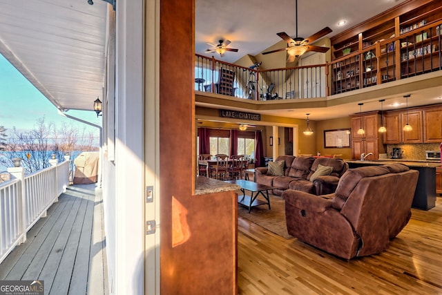 living room featuring sink, a towering ceiling, and light hardwood / wood-style floors