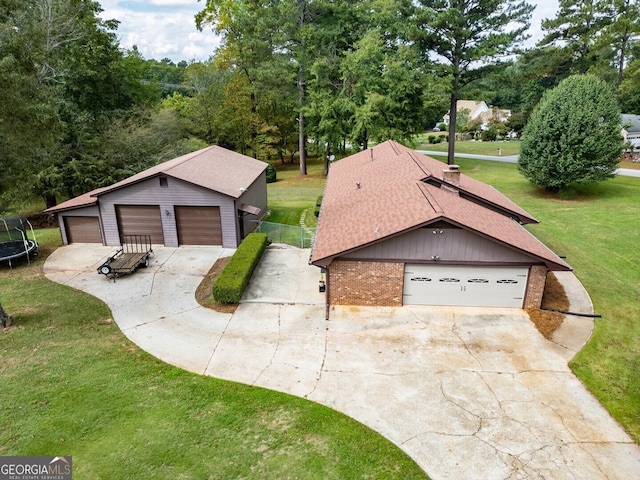 view of front of house featuring a trampoline, brick siding, a shingled roof, an outdoor structure, and a front lawn