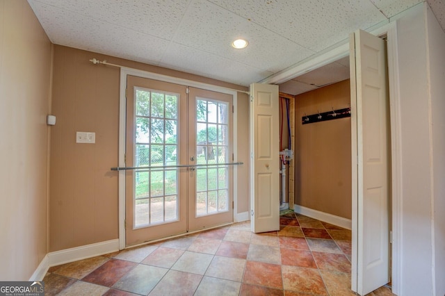 entryway featuring a paneled ceiling, french doors, and baseboards