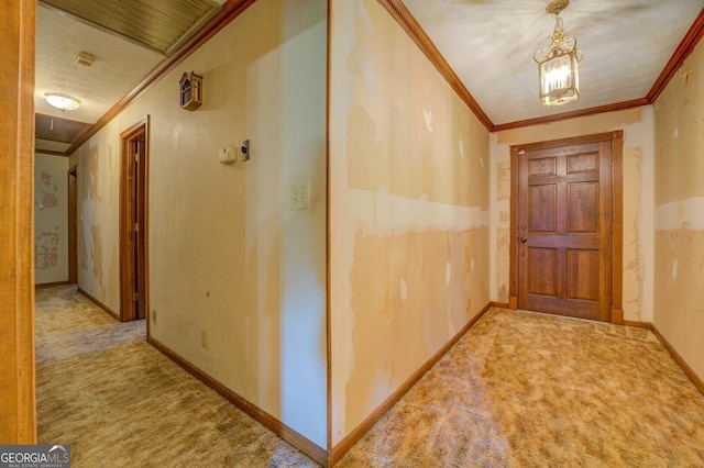 corridor with carpet, crown molding, a textured ceiling, and baseboards