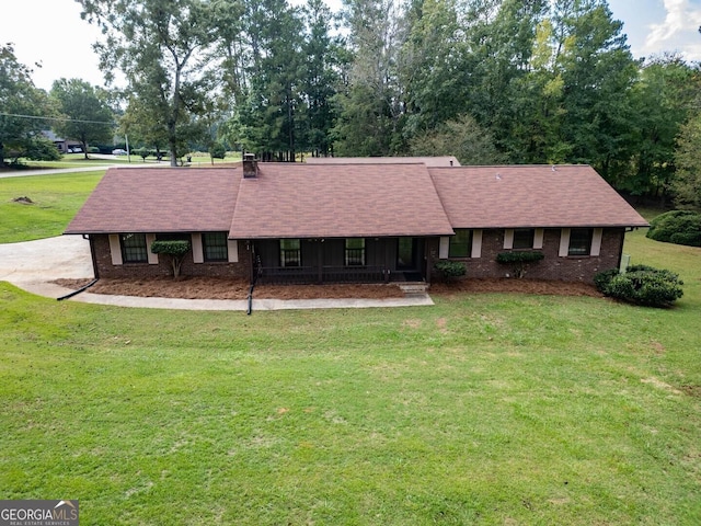 single story home with a front lawn, a shingled roof, and brick siding