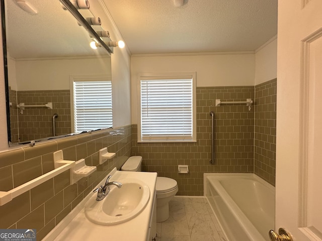 full bathroom with tile walls, vanity, toilet, crown molding, and a textured ceiling