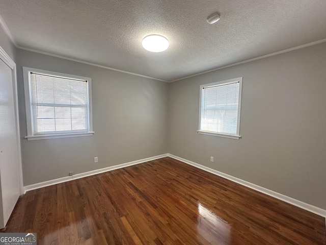 empty room featuring hardwood / wood-style flooring, crown molding, and a textured ceiling