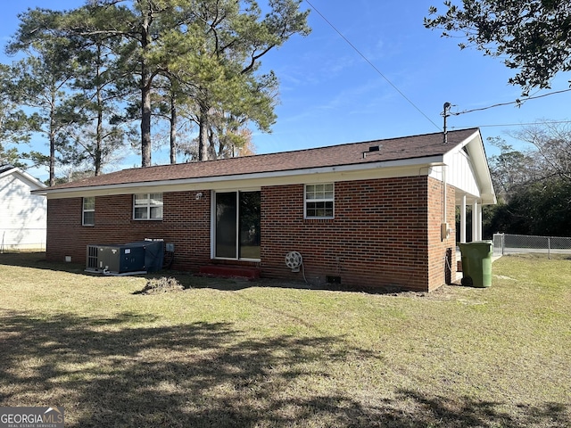 back of property featuring cooling unit and a lawn