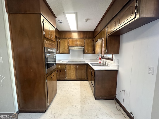 kitchen with black electric stovetop, sink, a textured ceiling, and stainless steel oven