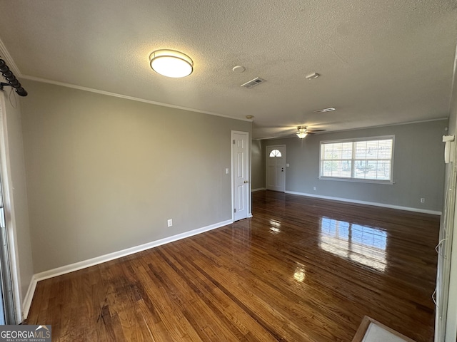 empty room with ornamental molding, ceiling fan, a textured ceiling, and dark hardwood / wood-style flooring