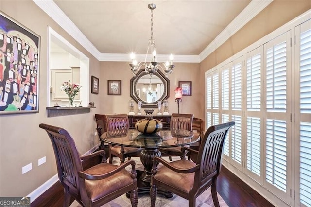 dining area featuring dark hardwood / wood-style flooring, a notable chandelier, and crown molding