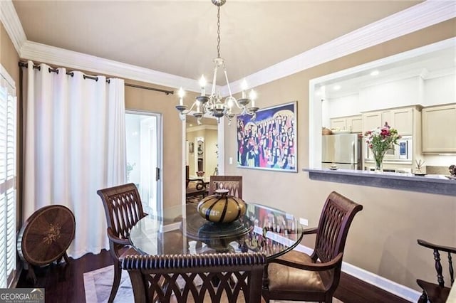 dining space with an inviting chandelier, crown molding, and dark wood-type flooring