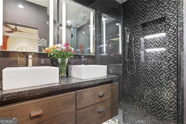 bathroom featuring vanity, ceiling fan, and a tile shower