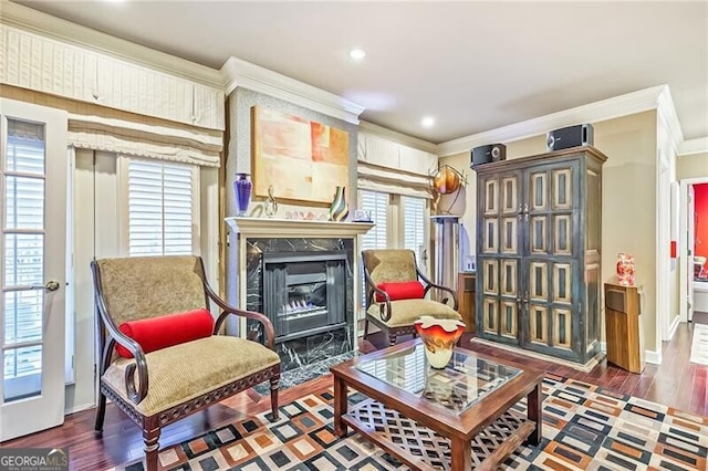 living area featuring ornamental molding, dark wood-type flooring, and a fireplace