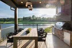 deck featuring exterior kitchen and a water view