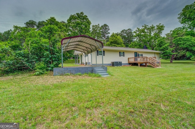 back of house featuring a carport, a yard, cooling unit, and a deck