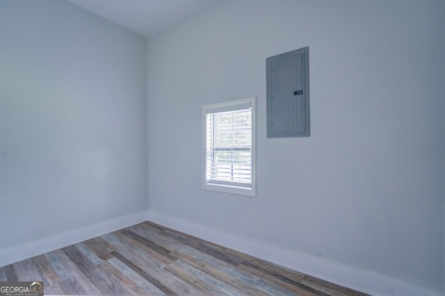 empty room with electric panel and light hardwood / wood-style flooring