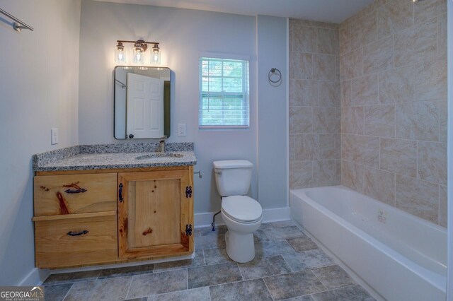 full bathroom with tiled shower / bath, vanity, and toilet