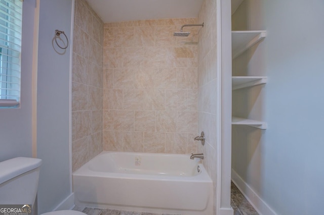 bathroom featuring tiled shower / bath and toilet