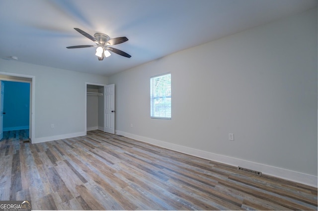 unfurnished bedroom with ceiling fan, a closet, and light hardwood / wood-style flooring