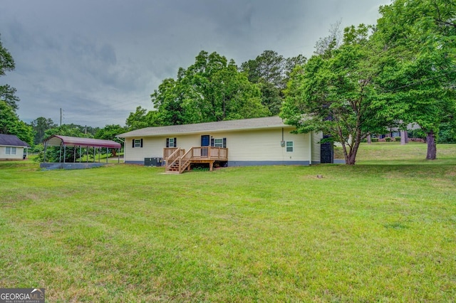 back of property featuring a carport, a yard, and a deck