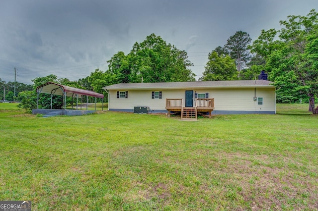 rear view of property with central AC, a carport, a deck, and a lawn