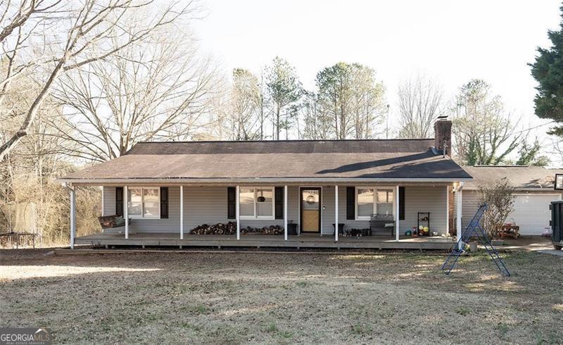 ranch-style house featuring a porch, a garage, and a front yard