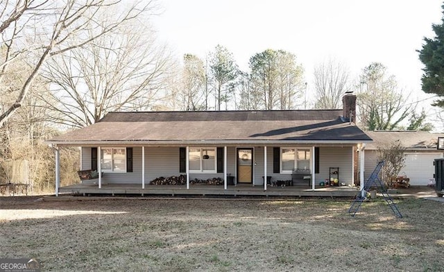 ranch-style house with a garage, covered porch, and a front yard