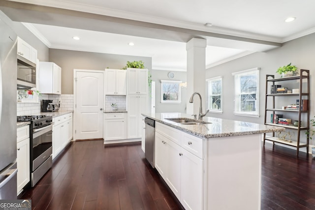 kitchen featuring white cabinetry, stainless steel appliances, light stone countertops, and sink