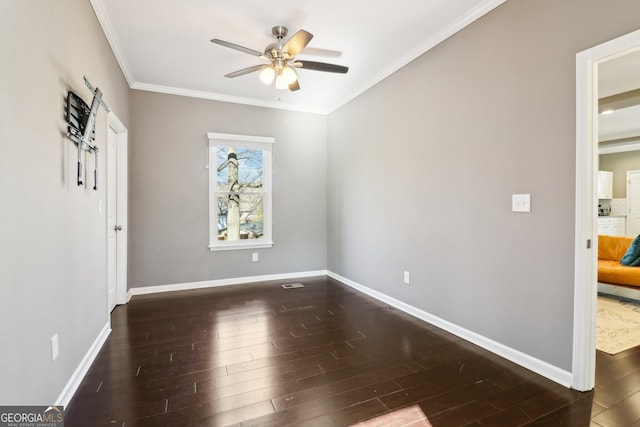 spare room featuring dark hardwood / wood-style flooring, crown molding, and ceiling fan