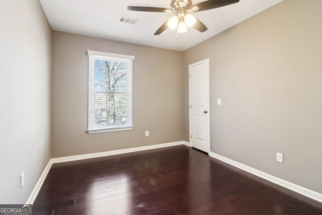 empty room with ceiling fan and dark hardwood / wood-style flooring