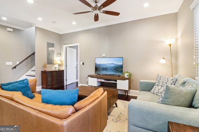 living room featuring hardwood / wood-style flooring, ceiling fan, ornamental molding, and electric panel