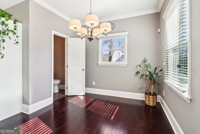 interior space with dark hardwood / wood-style flooring, crown molding, plenty of natural light, and an inviting chandelier