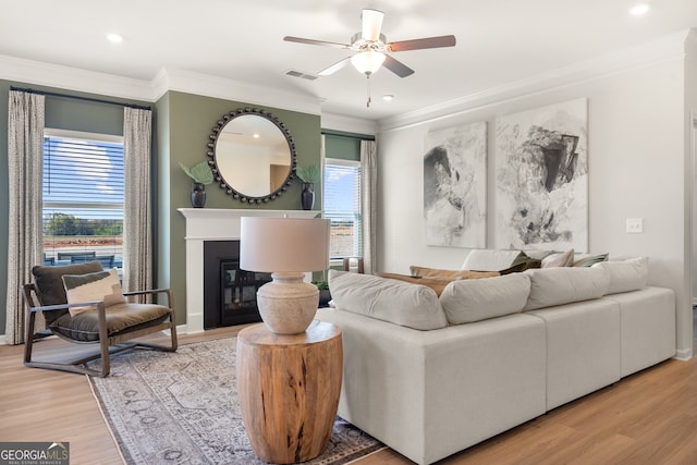 living room with crown molding, a healthy amount of sunlight, and hardwood / wood-style floors